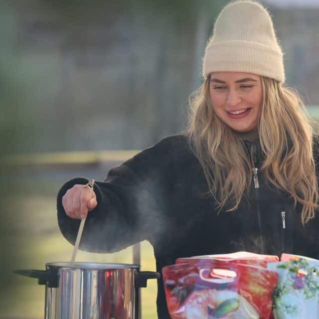 Julmarknad, glad tjej står och håller upp varm saft
